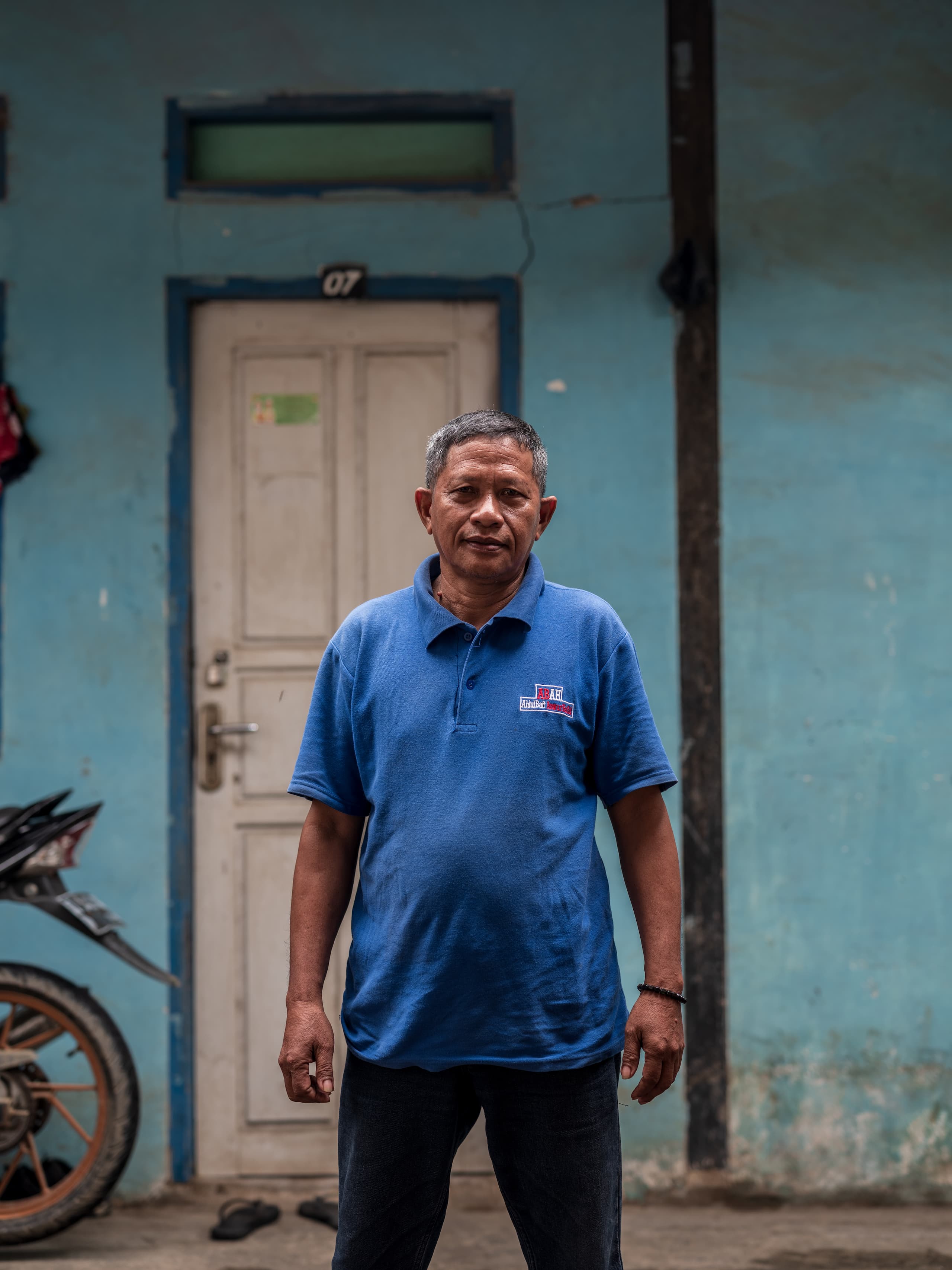 man in blue shirt standing in front of door