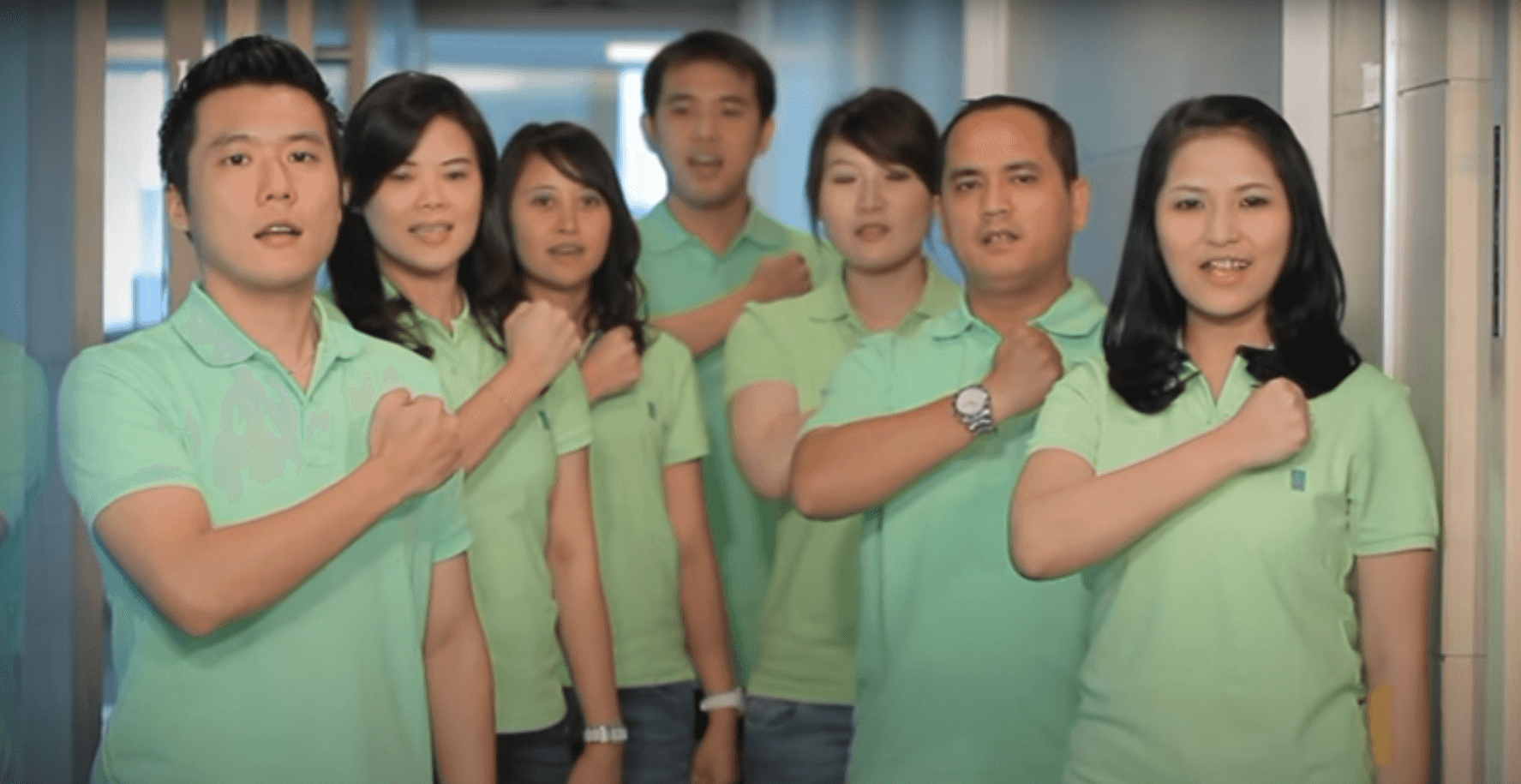 A screenshot of a video of First Resources employees singing the corporation's song.