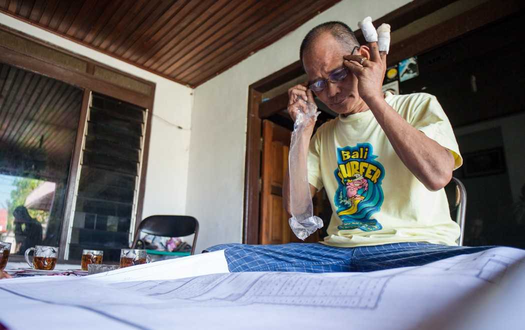 Marianto examines an oil palm concession map at his home in Kuala Pembuang.