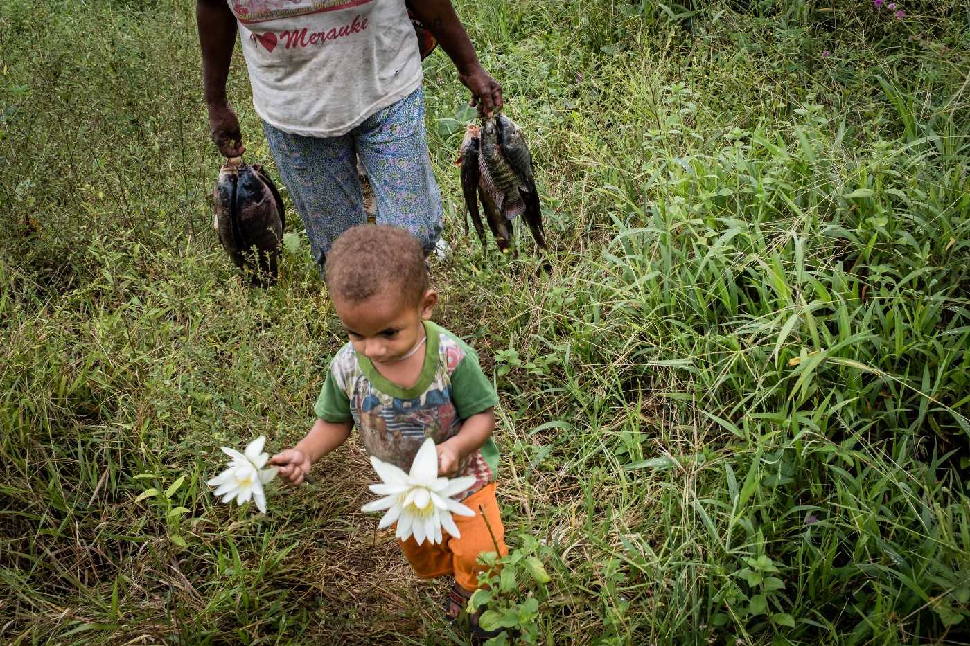 A Papuan man and child return from the Bian River in Muting.